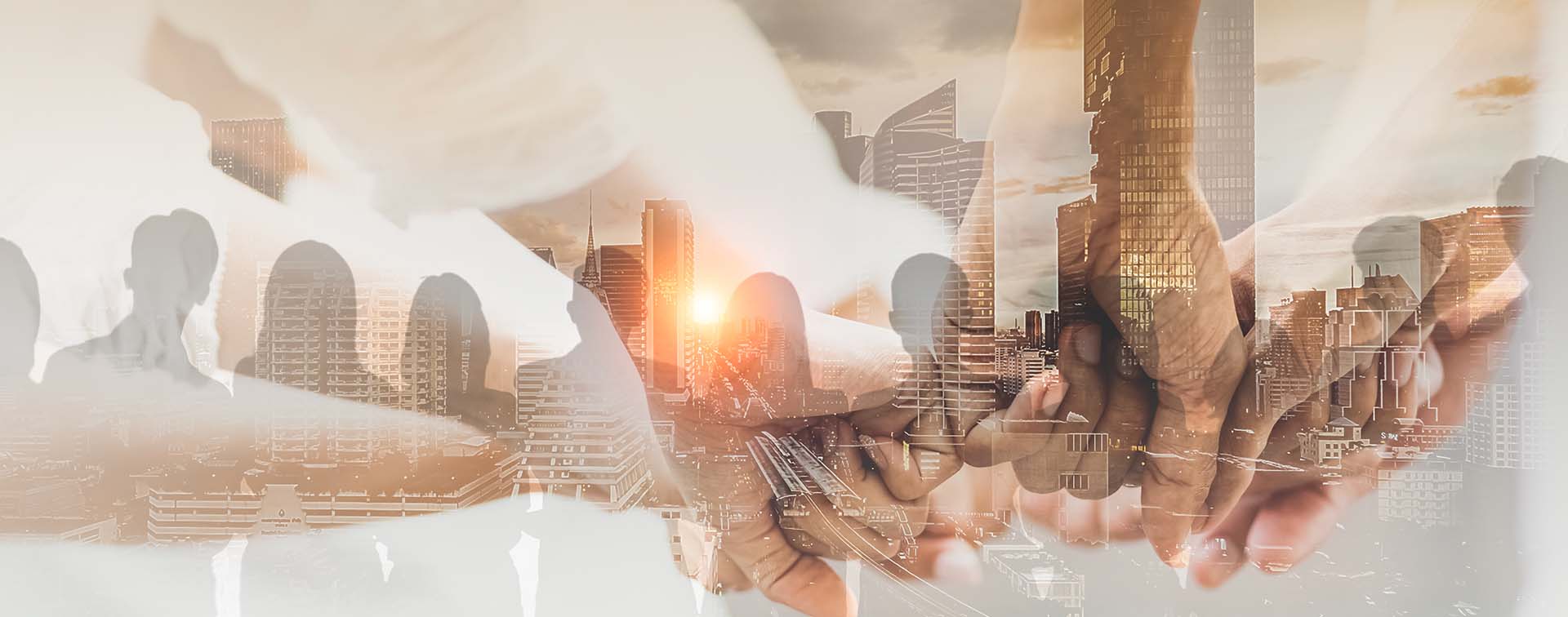 Digital composite of different-toned fists touching over the shadows of people standing beside each other looking at a skyline at sunset