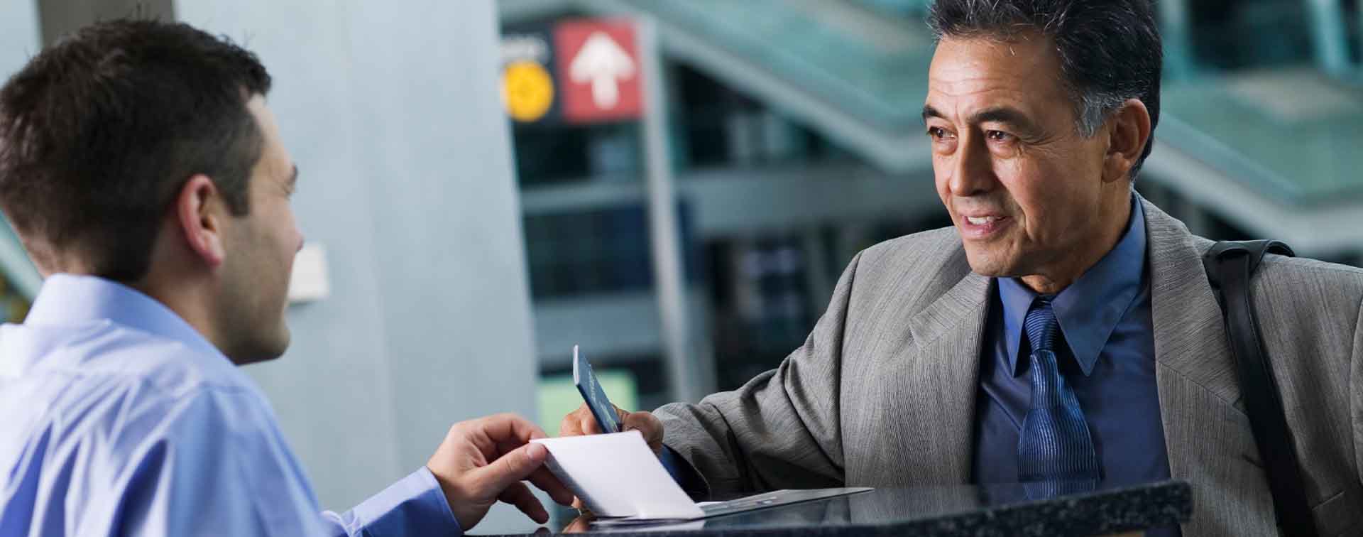 Man with passport at airport check-in desk