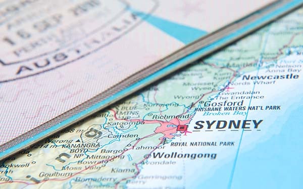 Extreme close-up of a map of Australia showing Sydney and a partial Australian passport lying over it.
