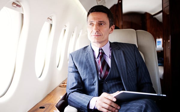 Caucasian business man sitting in a private airplane staring out the window