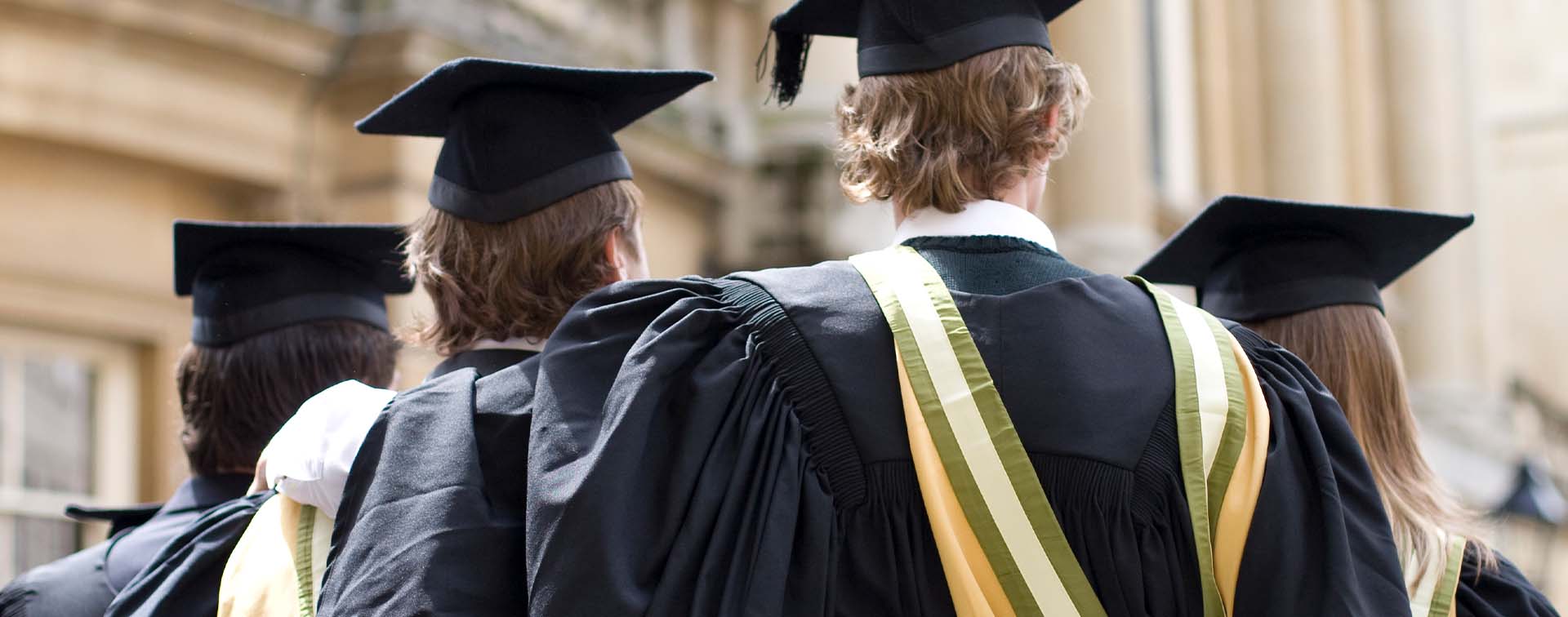 Graduating university students with their arms around each other