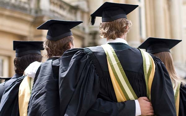 Graduating university students with their arms around each other