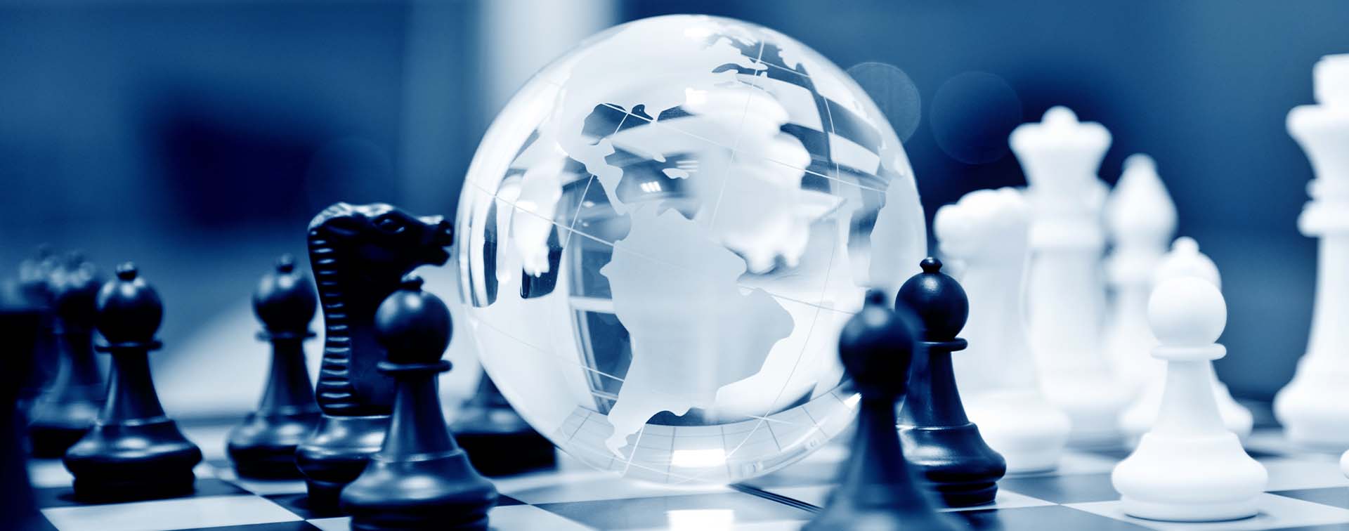 Crystal globe and chess pieces on chessboard