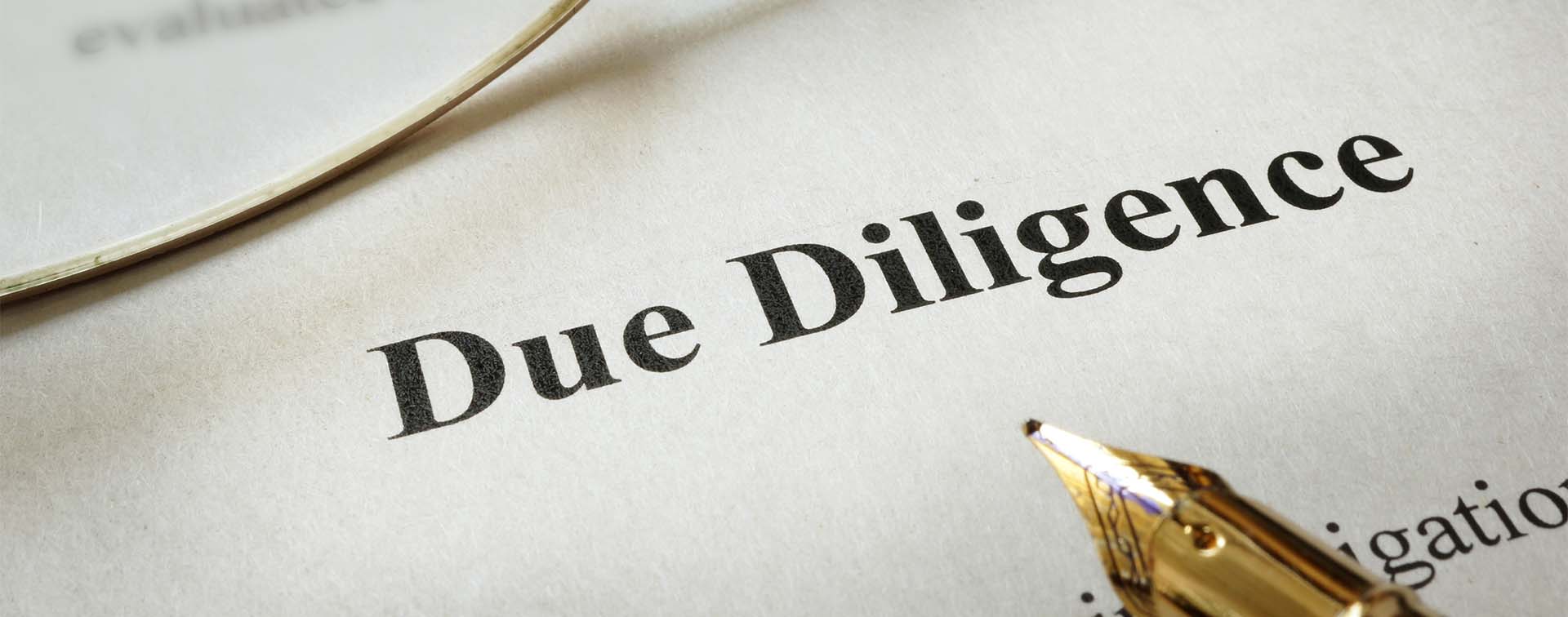Page of paper with words Due Diligence and glasses