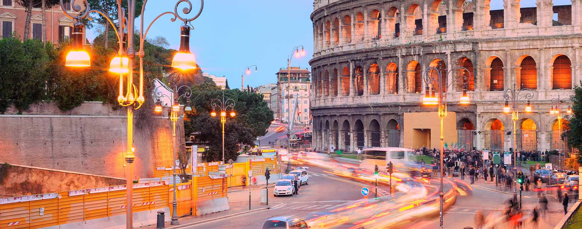 Colosseum, Rome, Italy, on sunset with timelapse of traffic at its base